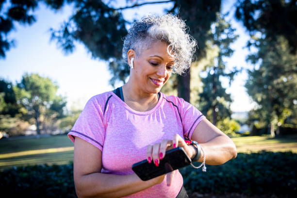 Senior Black Woman Running with a Fitness Tracker A beautiful black woman running with a fitness tracker. fitness tracker stock pictures, royalty-free photos & images