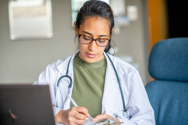 Telehealth A doctor works in her office, consulting with a patient via video call. north african ethnicity stock pictures, royalty-free photos & images