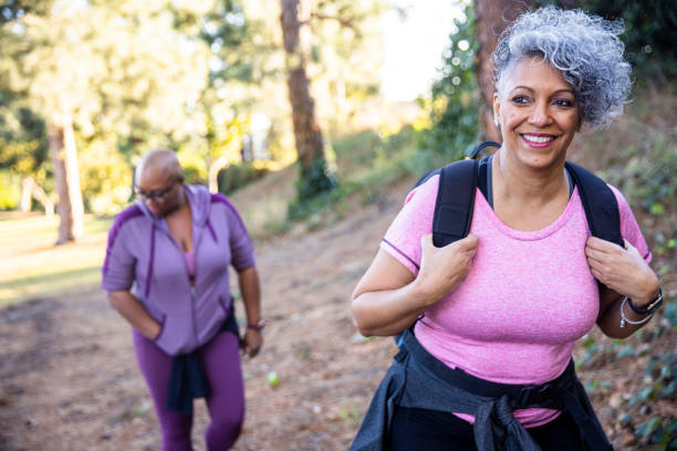 anziana donna nera che escursioni nella natura - hiking senior adult exercising outdoors foto e immagini stock