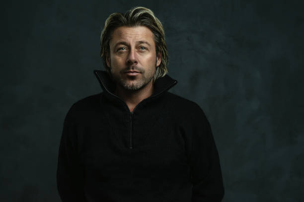 istock Serious blonde man in black woolen sweater. 1299848931