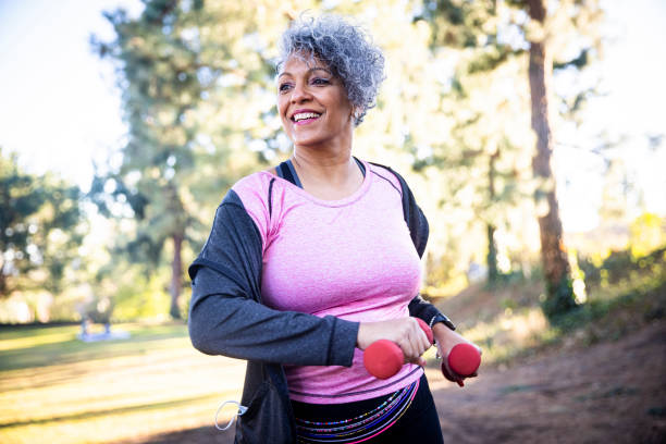 senior black woman stretching und training mit gewichten - aktiver lebensstil stock-fotos und bilder