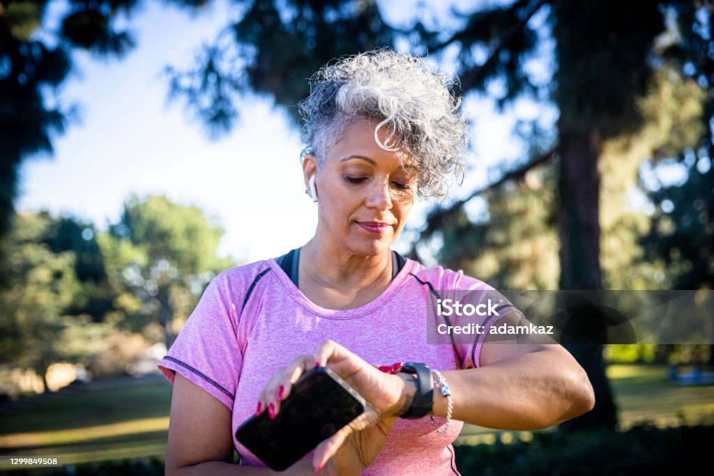 Senior Black Woman Running with a Fitness Tracker A beautiful black woman running with a fitness tracker. Smart Watch Stock Photo