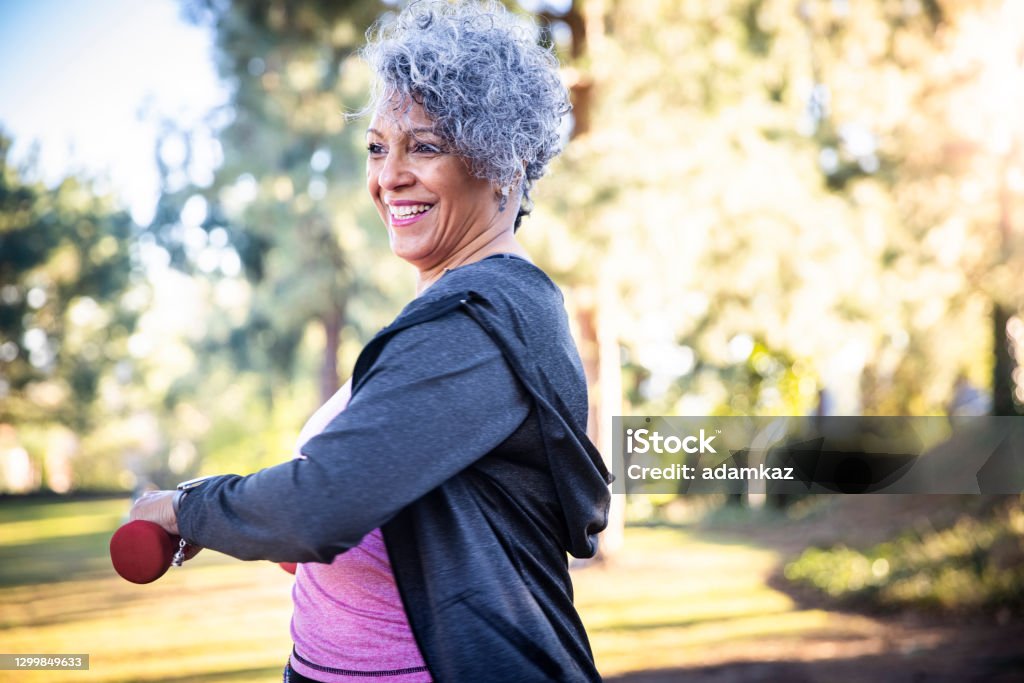 Senior Black Woman Stretching and Exercising with Weights A beautiful black woman using weights during her workout. Exercising Stock Photo