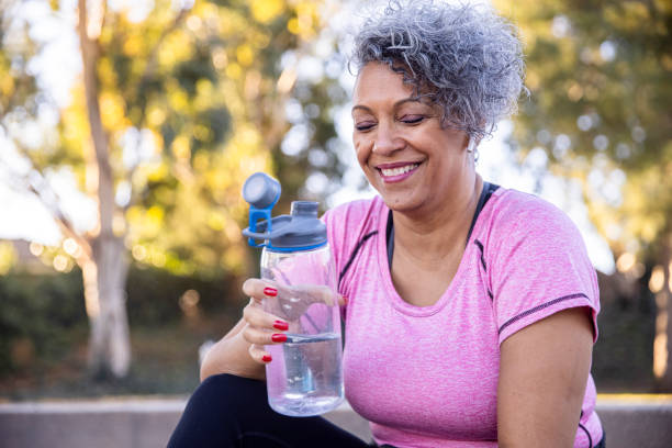 mujer negra hidratante después del entrenamiento - agua potable fotos fotografías e imágenes de stock
