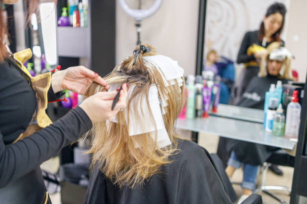 istock Using brush and foils in order to color woman's hair 1299850365