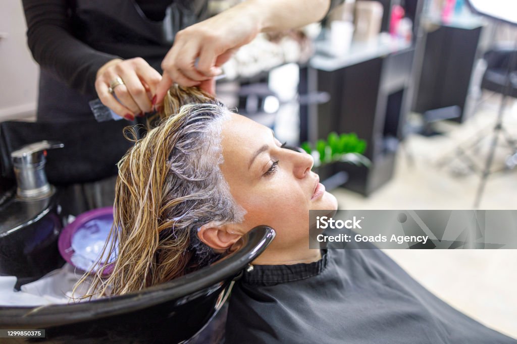 Woman having her hair washed after dying it blonde Young woman having her hair washed at hair parlor 35-39 Years Stock Photo Woman having her hair washed after dying it blonde Young woman having her hair washed at hair parlor 35-39 Years Stock Photo