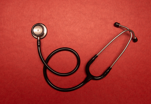 Stethoscope on red background.