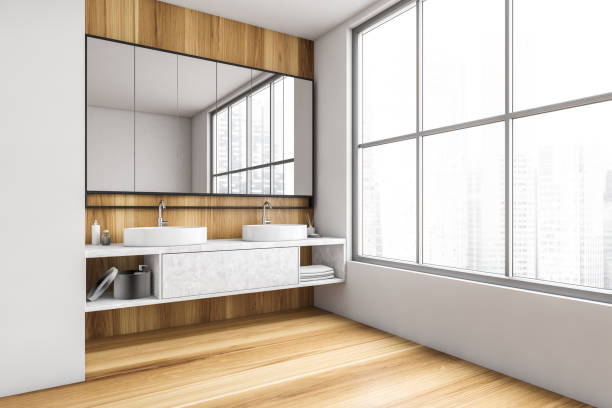 istock Wooden and white bathroom with two sinks, mirror and big window 1299850786