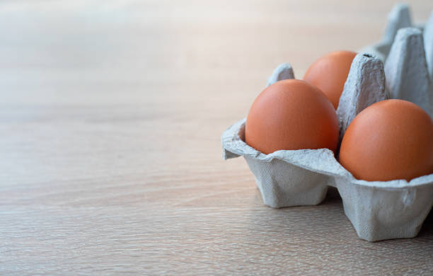 istock Closeup on carton of three fresh brown free range eggs 1299851585