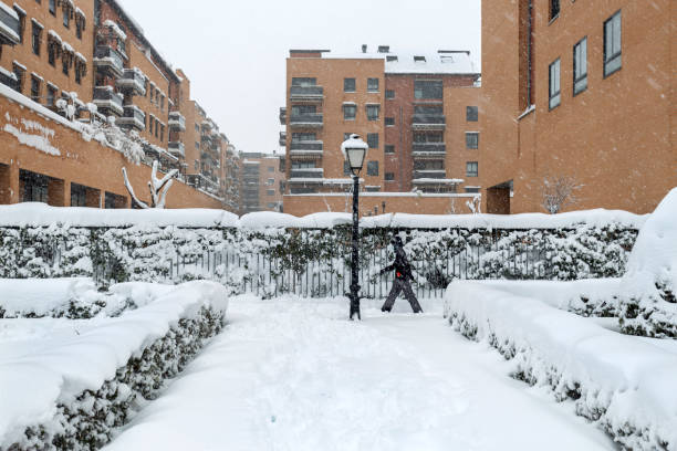 Senior adult couple walking on snowing sidewalk. Winter landscape.