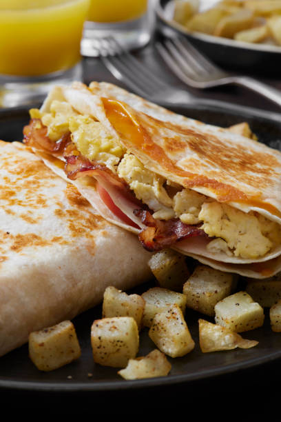 istock The Folded Breakfast Tortilla with Scrambled Eggs, Bacon, Tomato and Cheese 1299854108