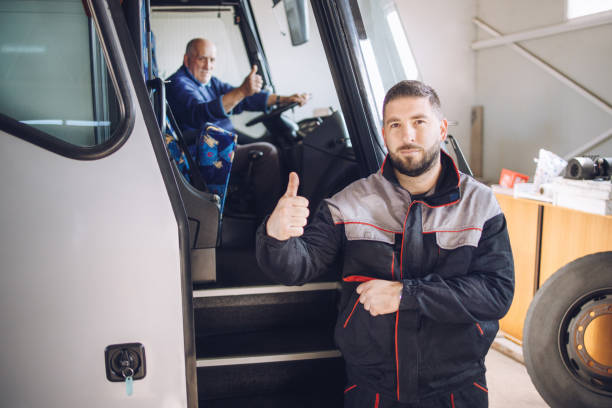 mecânico com o polegar para cima confirma ao motorista de ônibus que está tudo bem com o ônibus - adult manual worker automobile industry transportation - fotografias e filmes do acervo