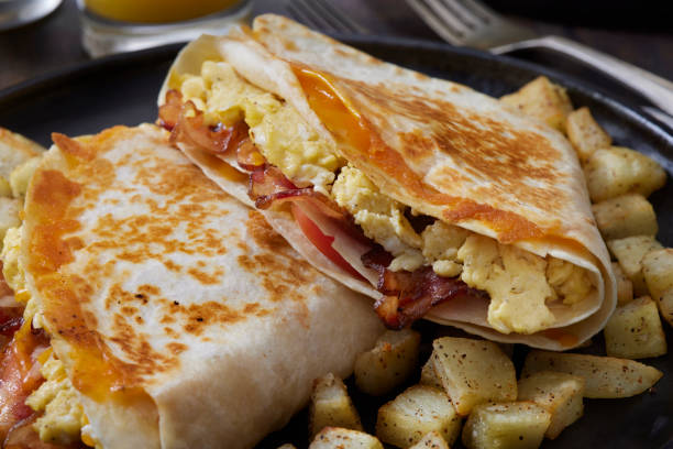 istock The Folded Breakfast Tortilla with Scrambled Eggs, Bacon, Tomato and Cheese 1299854809