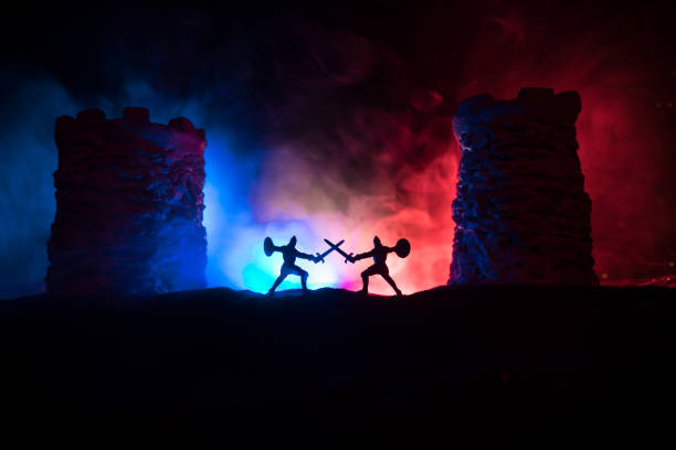 istock Medieval battle scene. Silhouettes of figures as separate objects, fight between warriors at night. Creative artwork decoration. Foggy background. 1299855172
