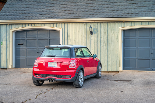 A Red colored Mini Cooper S small car is parked on a driveway in Hamilton, Ontario, Canada