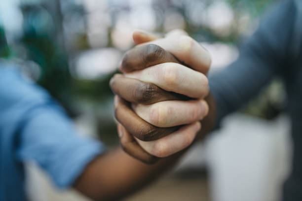 sparatoria in studio antirazzista di un gruppo irriconoscibile di persone che si tengono per mano - anti racism foto e immagini stock