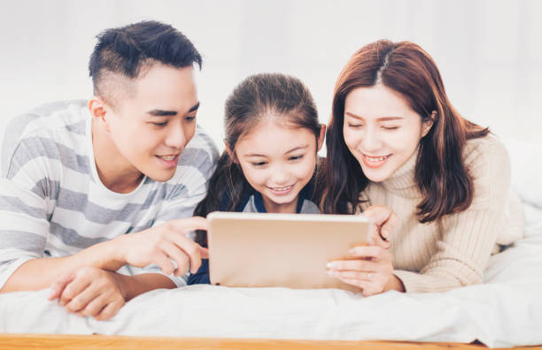 istock happy family using digital tablet in bed 1299858885