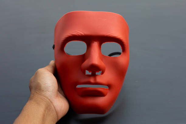 istock Hand holding face mask on dark background. 1299859524