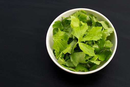 Chinese celery on dark background. Copy space