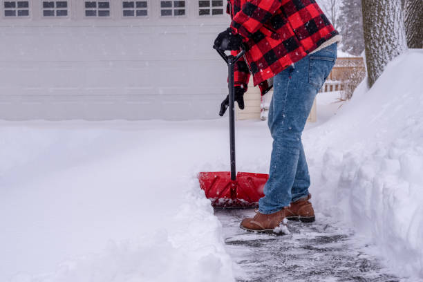 Man shoveling heavy snow in the driveway stock photo