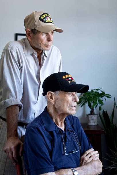istock World War Two Veteran and son Gulf War Veteran at home looking toward window 1299863415