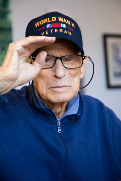 world war two veteran at home looking at camera saluting - armed forces us veterans day military saluting imagens e fotografias de stock