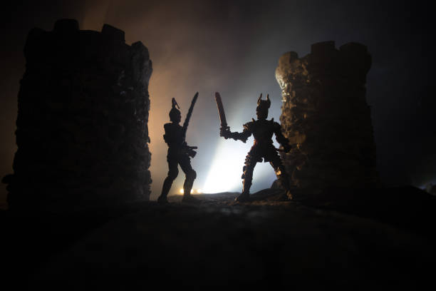 istock Medieval battle scene. Silhouettes of figures as separate objects, fight between warriors at night. Creative artwork decoration. Foggy background. 1299863430