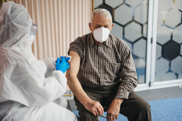 istock Senior man being vaccinated at doctor's office 1299863560