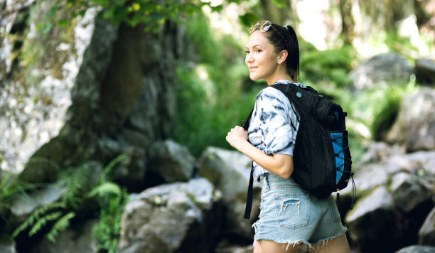 istock Young woman hiker with backpack travels outdoors in the mountains 1299864565