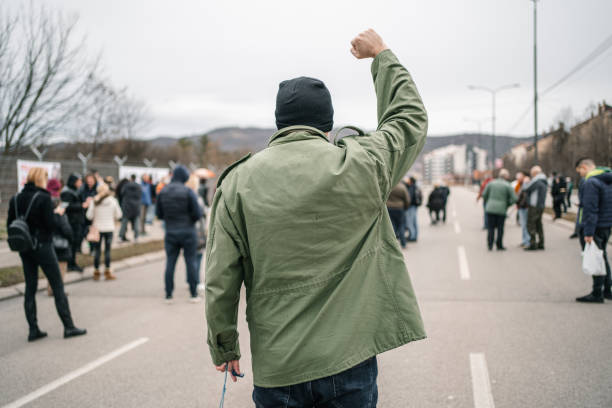istock Protestor with raised fist during a protest in a street 1299866399