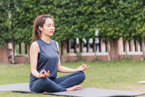 istock young woman doing yoga outdoors in meditate lotus pose 1299873882