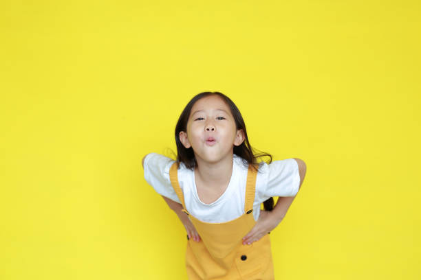 istock Cute little girl amazing expression isolated on yellow background 1299875637