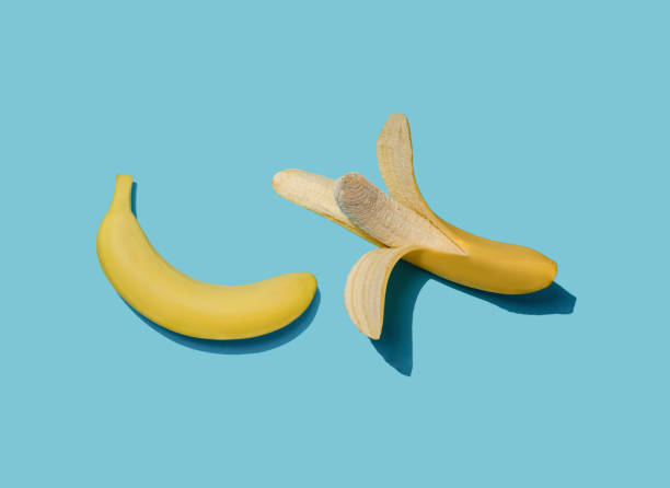 istock Peeled and unpeeled banana on light blue background. 1299875940