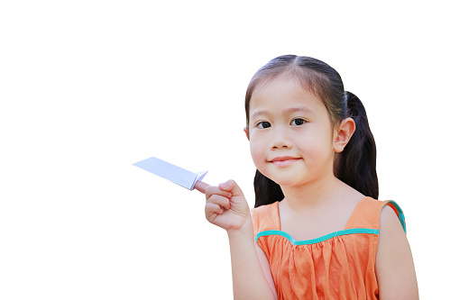 Asian little child girl fold a piece of white paper to rocket and showing on her forefinger isolated on white background. Education and imagination concept.