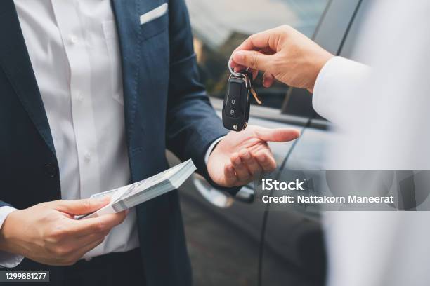 Closeup Hand Giving A Car Key And Money For Loan Credit Financial Lease And Rental Concept Stock Photo - Download Image Now