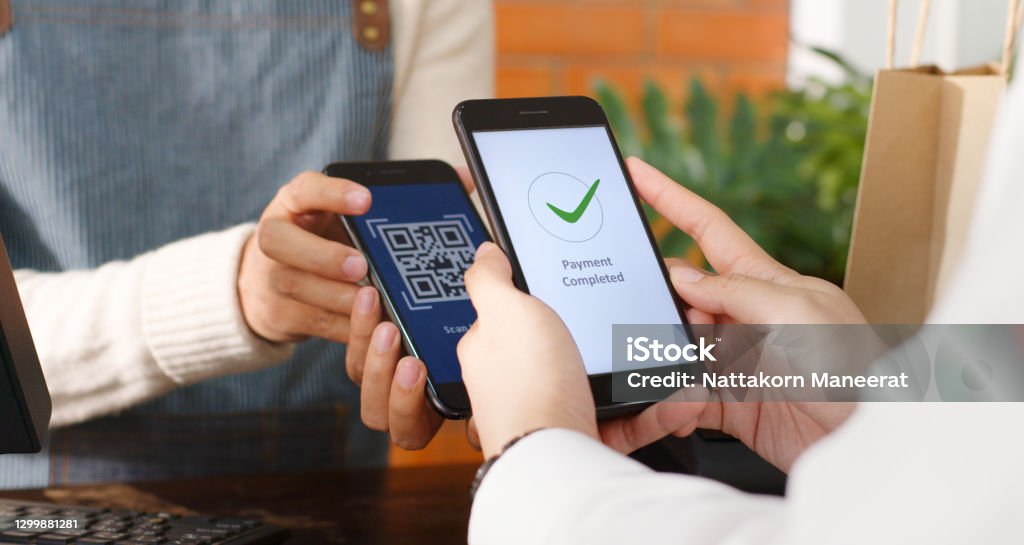 Customer using phone for payment at cafe restaurant, cashless technology and money transfer concept Paying Stock Photo