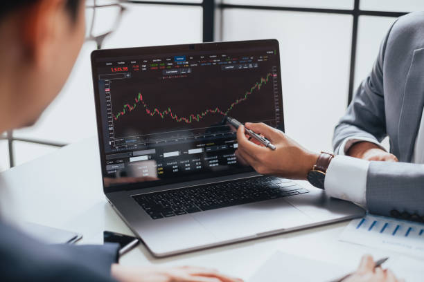 브로커 상인과 컴퓨터 노트북에서 투자 주식 시장과 그래프에 대해 이야기 하는 사업가, 돈 계획 관리 및 분석을 제공 - 주식 뉴 스 사진 이미지