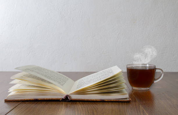 istock cup of coffee next to open book at home reader concept 1299882861