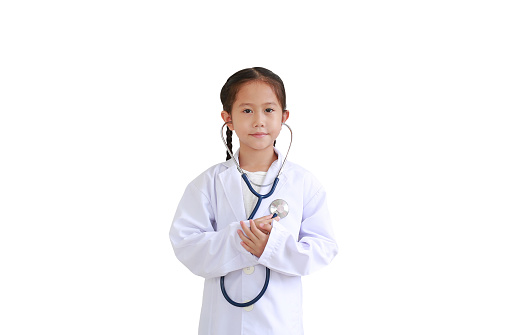 Portrait little asian kid girl with stethoscope while wearing doctor's uniform isolated over white background
