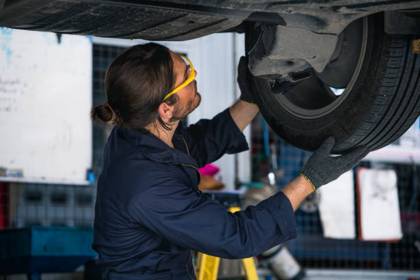 istock Engineer car mechanic under checking under the car by see detail in note book on hand for maintenance and fixed it. 1299885375
