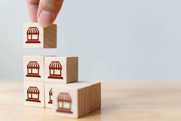 istock Franchise business marketing system concept. Structure service store network strategy. Hand putting wooden block on top with icon store 1299888184