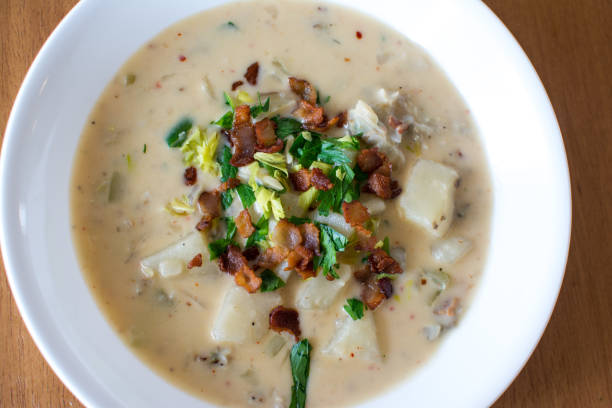 Homemade New England Clam Chowder Top View A homemade New England clam chowder un a shallow soup bowl Chowder stock pictures, royalty-free photos & images