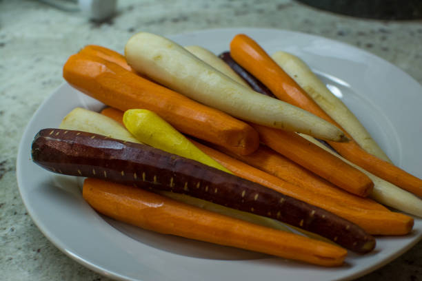istock Multicolored Peeled Artesanal Carrots on plate 1299888910