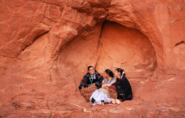 istock Cheerful Navajo sisters siting on a rock 1299893834