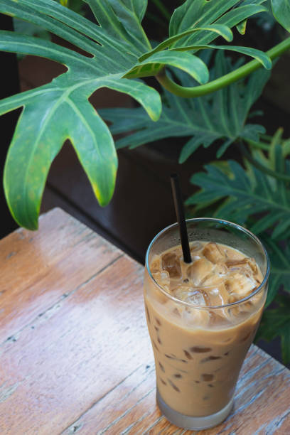 istock Iced milk coffee drink in green plant area 1299896427