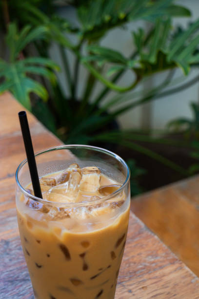istock Iced milk coffee drink in green plant area 1299896456