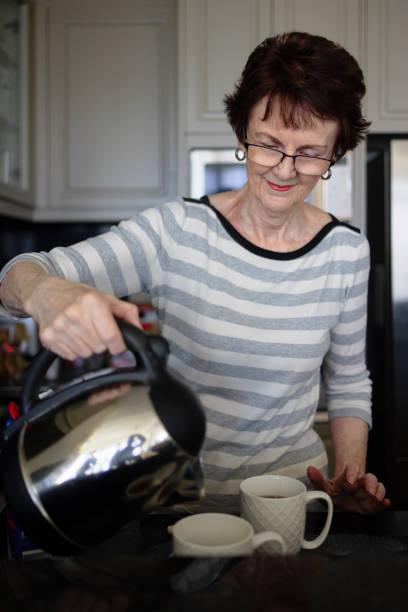 istock Woman making tea in the kitchen 1299896687