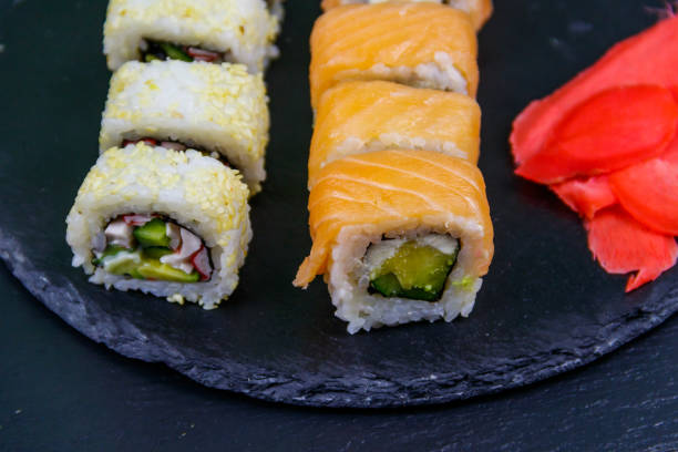 istock Set of sushi rolls on a black stone slate 1299897755
