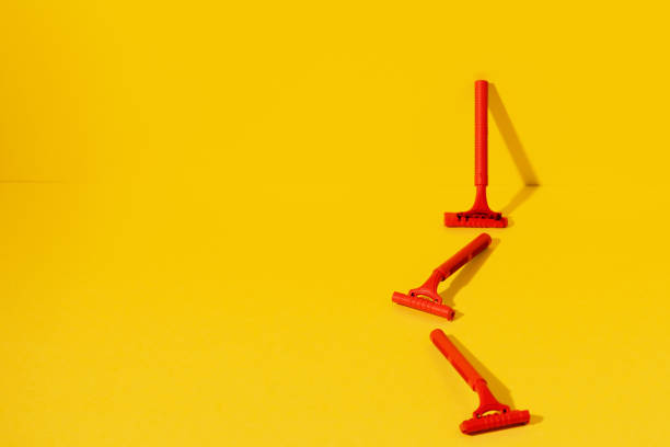 istock Disposable razors on yellow background, studio shot 1299898823