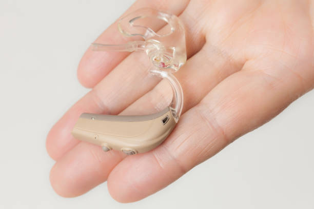 istock senior person holding hearing aid closeup 1299901065